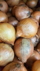Close up pile of fresh onions placed together in local market as a background.