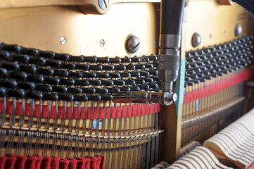 Tuner inside of a piano with little hammer