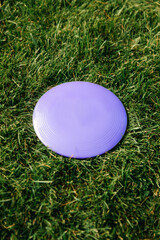 leisure games, toys and sport concept - close up of flying disc on grass
