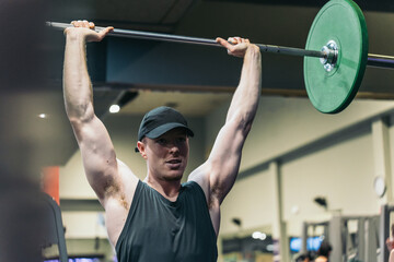 Red-haired athlete, arms extended, performing shoulder press.
