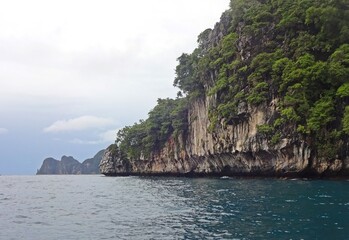 Naklejka premium The serene blue sea is complemented by a majestic mountain towering above it, PHI PHI ISLAND, THAILAND 