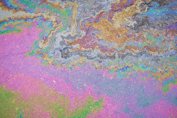 Marble spills on the water from traces of fuel and oil. Abstract background from spilled motor oil, gas or gasoline on the asphalt.