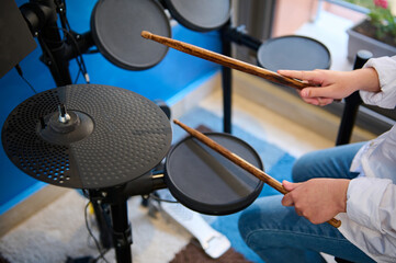 Teenage drummer hands. Teen boy playing drums in music studio. Top view of boy musician beating on...