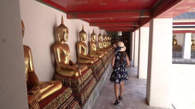 Tourists look at golden Buddha in Temple ,  Bangkok Thailand