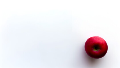 Artistic shot of a single, vibrant red apple on a white surface, 