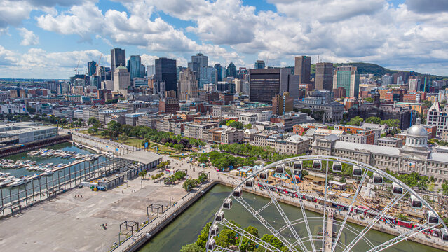 Aerial panoramic view of downtown Montreal financial district and the historic old port on a summer day, Mount Royal mountain in the backdrop, Quebec, Canada. Photo taken by drone in August 2021.
