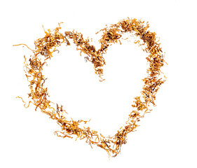 A pile of shredded tobacco for cigarette rolling in a heart shape, top view, isolated on a...