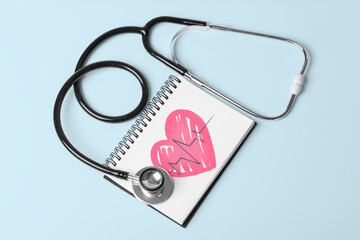 Stethoscope and Pulse Heartbeat Notebook Still Life Object on Blue Background