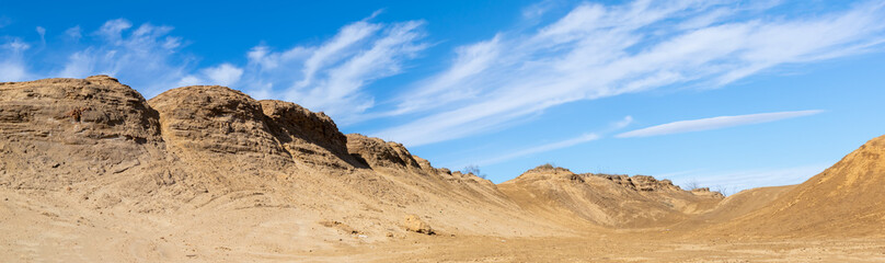 Fototapeta na wymiar dunes of yellow sand against the sky, heap in Bytom in Poland, panorama