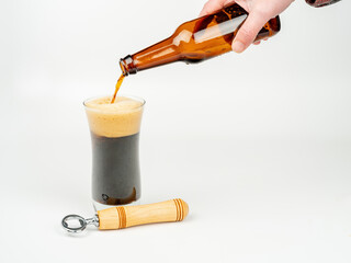 Beer is poured into a glass with bottle opener