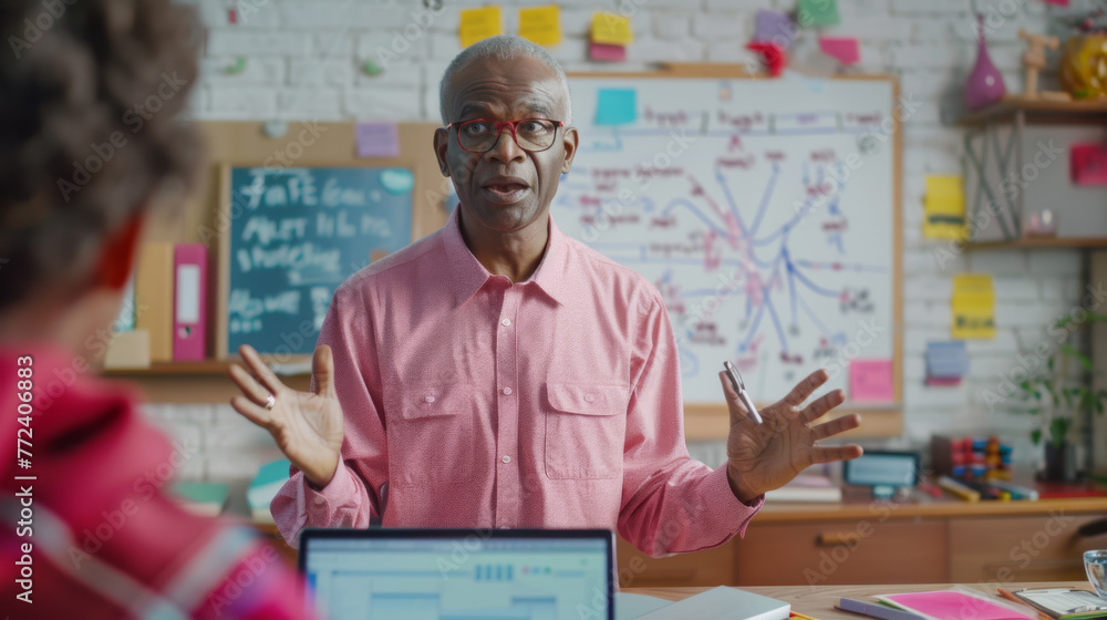 Poster a professional gestures while explaining a concept with a whiteboard in the background.