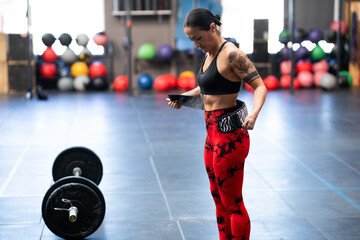 Woman tying a belt to prevent injures while weightlifting