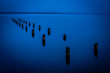 Verfallener Holzsteg am Starnberger See zur blauen Stunde am Abend