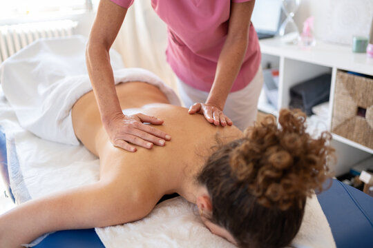 Professional massage therapist rubbing back during rehabilitation