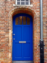 old blue exterior door in brick wall