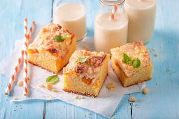 Sweet and delicious peach cake with glaze and crumbles.