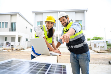 electrician man and woman in safety vest with helmet use laptop for check solar cell plant. Green...
