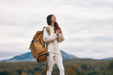 Mountain Adventure: Smiling Woman on Cliff, Enjoying Backpacking Journey in Springtime