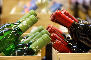 Wine bottles in wooden boxes. Liquor store, red and white wine retail