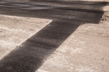 New asphalt patch laid on repaired road closeup