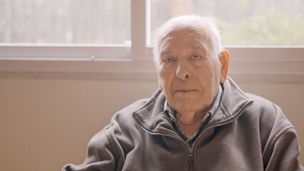 Aged man looking serious sitting on a geriatric