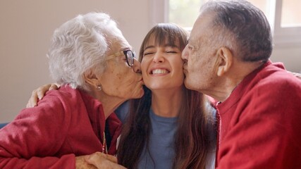 Grandparents kissing their granddaughter while she visits them