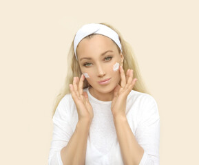 woman applying serum, lotion to her face