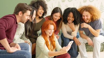 Friends looking at a mobile and laughing at one video