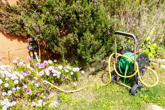 Garden hose connected to automatic irrigation system. Gardening concept.