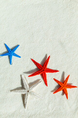 Colored starfish on white fine sand.