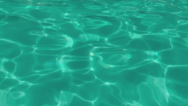 An amazing view of swaying turquiose waters in a modern swimming pool with shimmering curvy lines making a cheerful and arty background. abstract background animation: sea, swimming pool, water (4K)