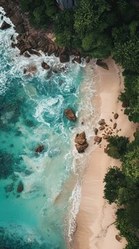 Aerial view of waves hitting rocky shores with sandy beach and forest.