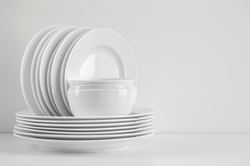 A stack of white plates and bowls on a table. Perfect for kitchen or dining room themes