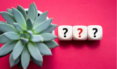 Question marks symbol. Concept words question mark on wooden cube. Beautiful red background with...