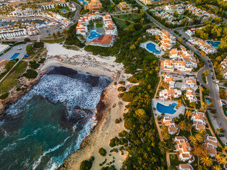 Aerial drone view of the harbor and the beach of Cala en Bosc, Menorca. - 772501855