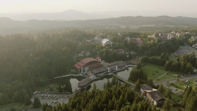 On a sunny and partly cloudy day, filmed with a drone a vacation lodge nestled in the midst of mountains and forest