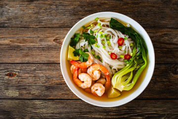 Shrimp Pho soup - Vietnamese soup with shrimps on wooden table
