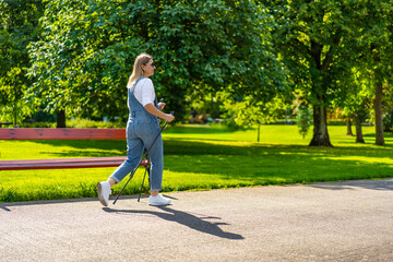 Nordic walking - woman exercising in city park
