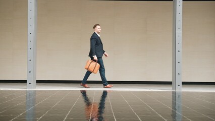 Side view of business people holding suitcase and walking to workplace along the street in urban city. Professional project manager going to meeting while wearing formal suit walk at outdoor. Urbane.