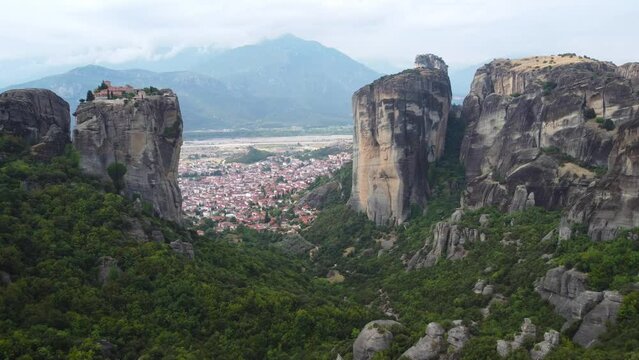 Aerial view of Monastery of the Holy Trinity (Agia Triada) in Meteora, Greece with Kalabaka town and mountains in the background