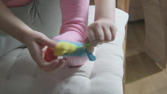 Young kid achieving self-dressing milestones, Toddler developing self-help skills by donning colorful cotton socks with separated toes, Childhood Milestones, Growing independence