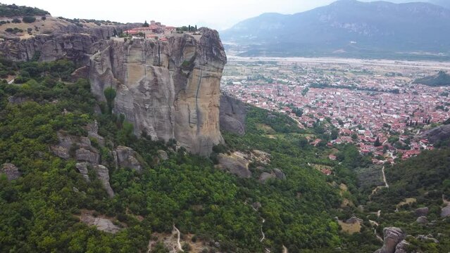 Aerial view of Monastery of the Holy Trinity (Agia Triada) in Meteora, Greece with Kalabaka town and mountains in the background