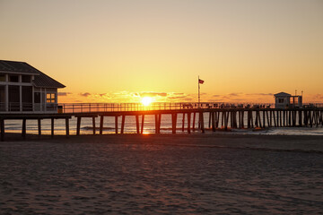 Fototapeta na wymiar Early morning dramatic sunrise over the ocean and long pier