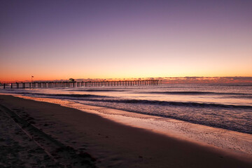 Early morning dramatic sunrise over the ocean and long pier