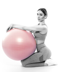 Slim, bodybuilder girl in a lilac tracksuit, sitting on a mat with a Pilates ball,  cardio workout....