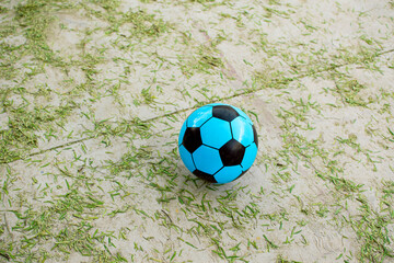 Imagen horizontal de una pelota color azul sobre el suelo de cemento 