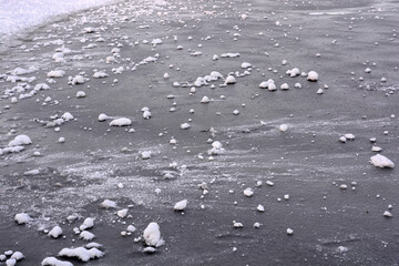Beautiful and unusual backgrounds of nature, a thick layer of ice with pieces of white snow, winter...