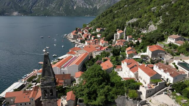 Aerial revealing the mountain houses of Perast town with seafront in the Bay of Kotor in Montenegro