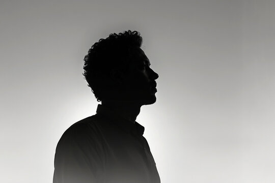 Perfil masculino a contraluz en balnco y negro rodeado de luz suave