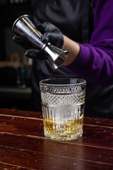 a bartender prepares a negroni cocktail 